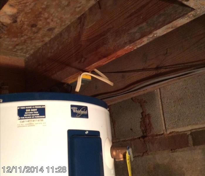 Hot water heater under a stairwells wood framing