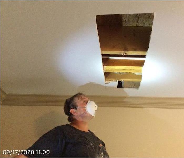SERVPRO technician with a ceiling with opened sheetrock