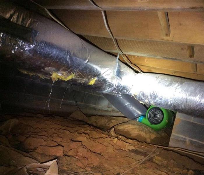 Crawlspace with a dirt floor and SERVPRO drying equipment