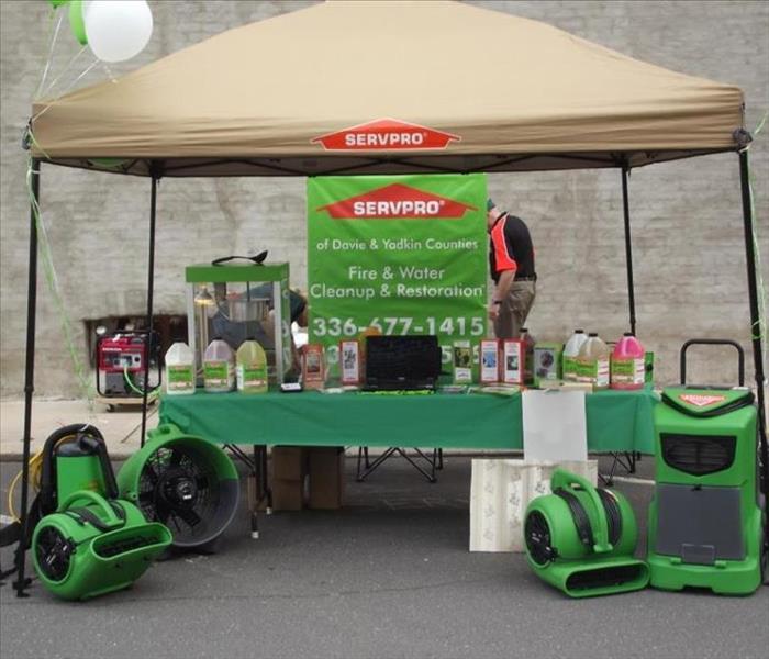 Tan SERVPRO tent with a green table and SERVPRO equipment setup