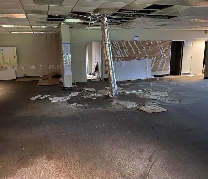 Room with damaged ceiling tiles and wet carpet