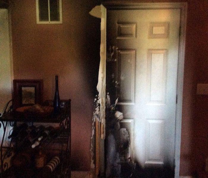 Fire damage and charring around door and wall