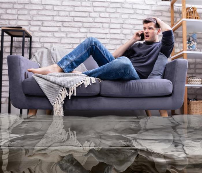 man on couch with rising water